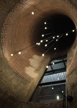 Upward View of Circular Brick Ceiling with Hanging Lights Foto stock
