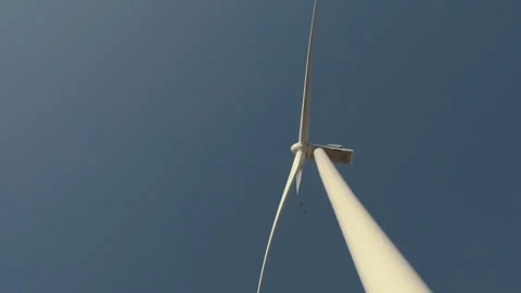 Upward View of a Spinning Wind Turbine Against a Clear Sky Stock Footage 282927213