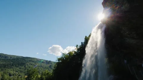 Upward View of Waterfall with Bright Sunlight – Dramatic Nature Perspective Stock Footage 310535036
