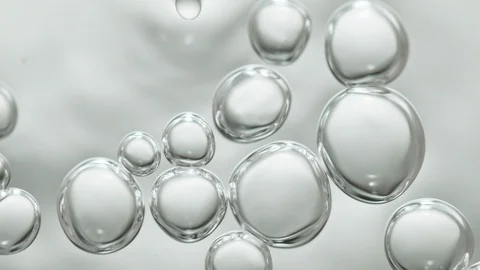 Upwards drifting transparent bubbles in low angle on white background Видео 117403231
