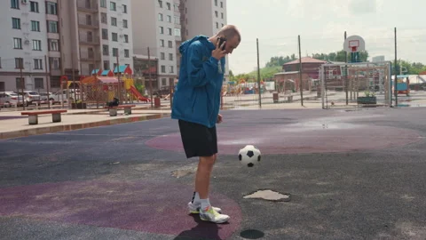 Urban athlete plays under rain, Solo soccer training in rainy city environment Stock Footage 327907258