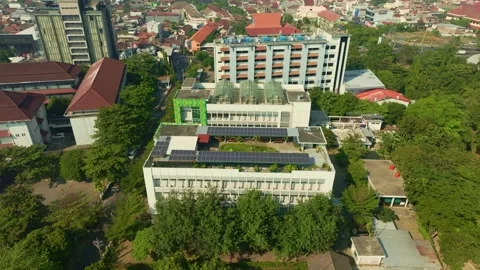 Urban building complex with rooftop solar panels in Yogyakarta 動画素材 342581010