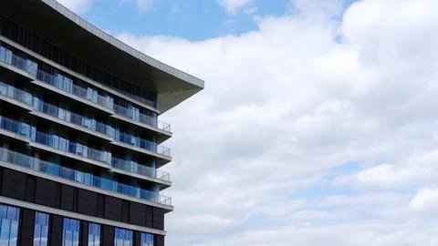 Urban building featuring modern architecture with curved lines, glass balconies Stock Photos