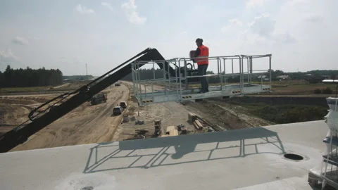 Urban building site. Construction worker elevating an industrial crane. Bridge Stock Footage 143564138