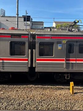 Urban Commuter Train Side View with City Background and Blue Sky Stock Photos