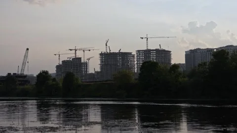 Urban construction site with tower cranes reflecting on water Stock Footage 344865041