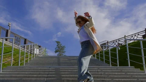 Urban contemporary dancer gracefully performing on outdoor stairs 動画素材 292727862