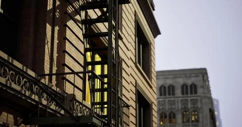 Urban evening view featuring fire escape on building in city center Illustrazione stock