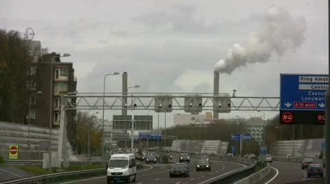 Urban expressway, with smoke stack in back ground. Stock Footage 108302