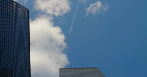 Urban flight as plane soars between towering skyscrapers. highlights interplay Stock Footage 277930706