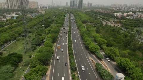 Urban Flow 4K Aerial Reverse of Expressway Amidst Greenery and Buildings 動画素材 261058002