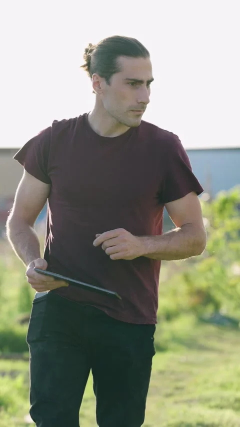 Urban gardener analyzing crop data on a tablet. Vertical Stock Footage 345205983