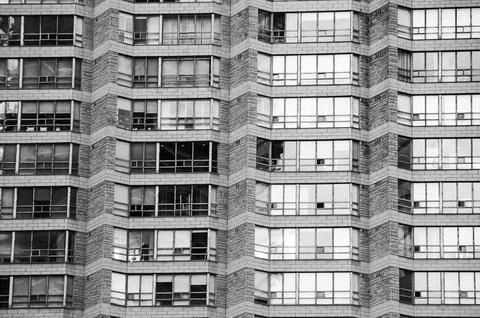 Urban geometry. Rows of large windows with various curtains, shutters, blinds Stock Photos