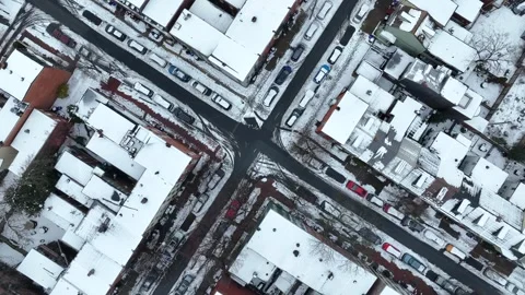 Urban intersection in snow covered American city. Top down aerial orbit. Stock Footage 263726291