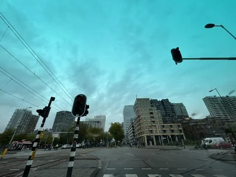 Urban intersection with tram lines, traffic lights, modern apartment buildings Stock Photos