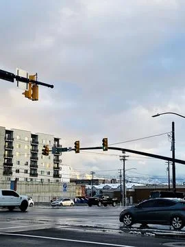 Urban intersection in Utah with traffic lights, cars and snowy mountains in.. Stock Photos