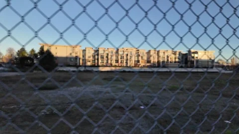 Urban Landscape Through Chain Link Fence at Dusk Stock Footage 257869864