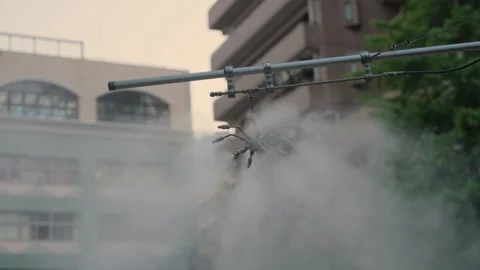 Urban misting system spraying water vapor in Tokyo Stock Footage 340644692