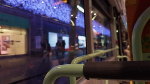 An Urban Night Scene Viewed from Inside a Bus Window Featuring Vibrant and Stock Footage 318554694