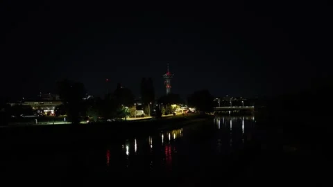Urban nightscape with illuminated tower glowing red above city skyline while ref Stock Footage 316701748
