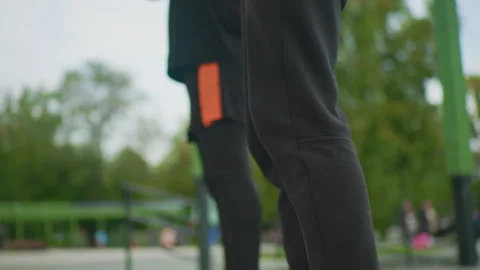 Urban park setting featuring energetic squat exercise with friends, Closeup of Stock Footage 325026462