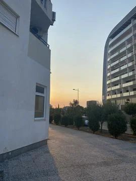 Urban pathway runs between modern residential buildings at sunset Stock Photos