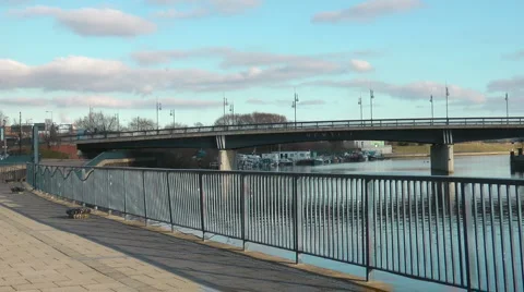 Urban riverside path with road bridge over river Stock Footage 1063516