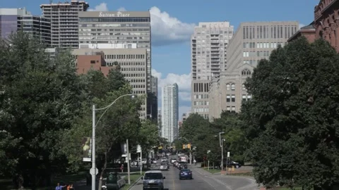Urban road traffic flowing through downtown with tall buildings Vidéo 341032876