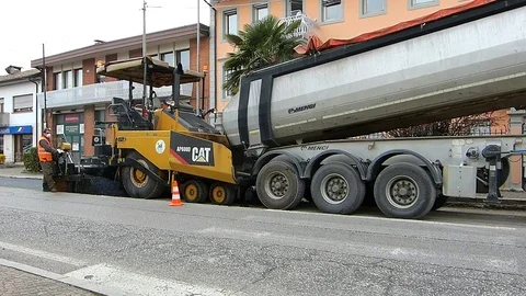 Urban road under construction, asphalting in progress. Worker in orange uniform. Stock Footage 73578467