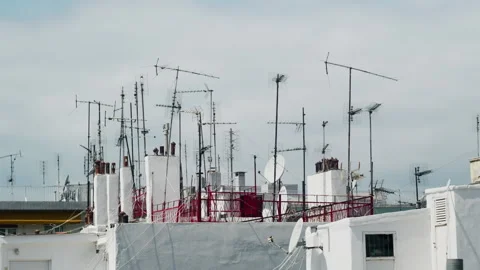 Urban Rooftop with Array of TV Antennas and Satellite Dishes 库存影片 333615310