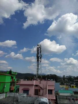 Urban Rooftop with Communication Tower and Cloudy Sky Foto stock