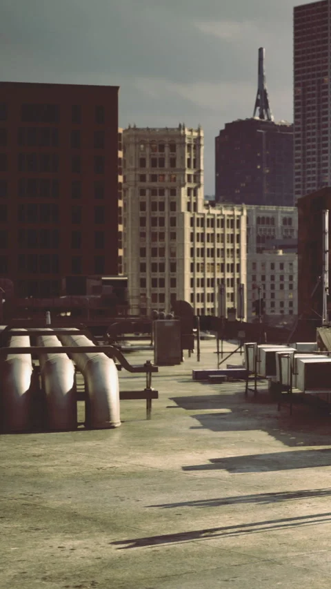 Urban rooftops basking in warm afternoon light with city skyline view Stock Footage 331696736