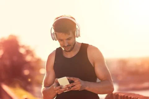 Urban runner using smartphone for training Stock Photos