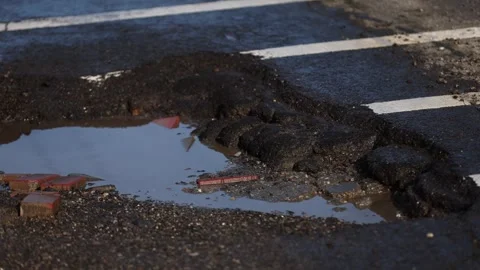 Urban scene with car passing by a big pothole in the asphalt Vídeo Stock 333317455