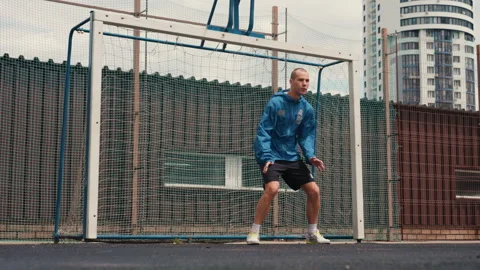Urban setting with focused goalkeeper in action, Gritty urban rooftop setting Stock Footage 337652360