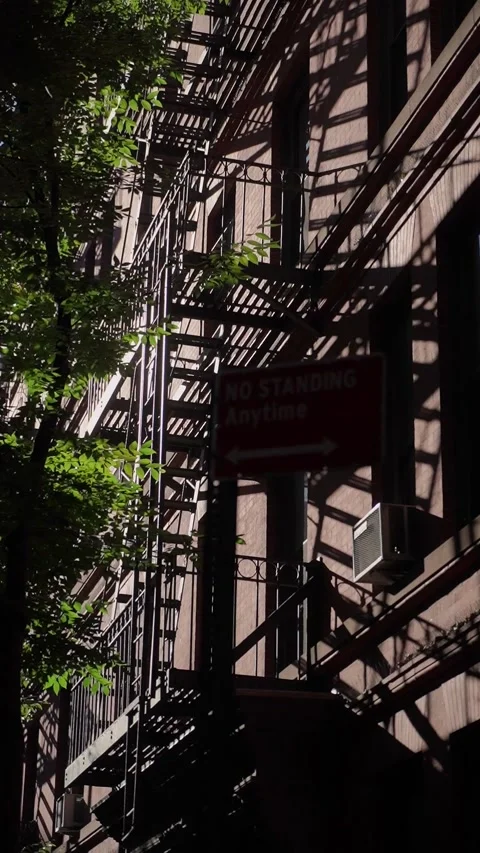 The Urban Shadows dance gracefully on a Fire Escape at Dusk within a Bustling, Stock Footage 291017287