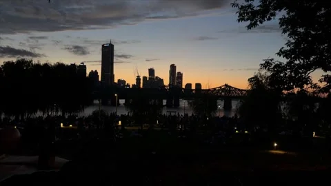 Urban skyline with bridge over river at sunset, dark silhouettes of skyscrapers Video stock 337107875
