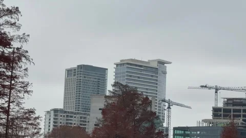 Urban Skyline with Construction Cranes on Cloudy Day Stock Footage 344596555