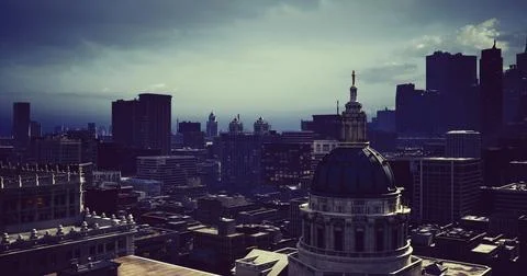 Urban skyline at dusk with dramatic lighting over city buildings Stock Illustration