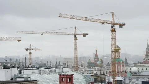 Urban skyline with multiple tower cranes rising above historic domes and ornate Video stock 327322439