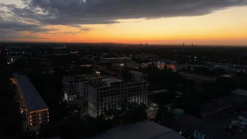 Urban skyline at sunset with construction cranes and city lights emerging Stock Footage 339124593