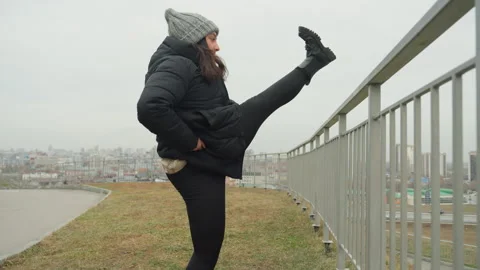 Urban skyline warmup exercises. Practicing high kicks against city backdrop Stock Footage 332368569