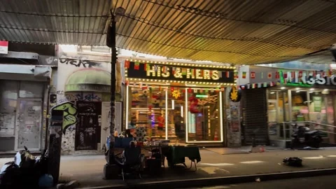 Urban Storefronts and Traffic Under Scaffolding on Busy Brooklyn Street at Night Stock Footage 340143407