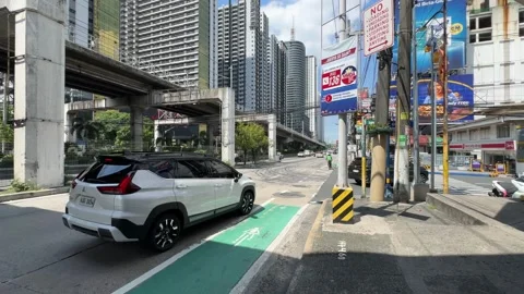 Urban Street Scene with Elevated Train Tracks in Mandaluyong City 4K 60fps 스톡 동영상 338278107