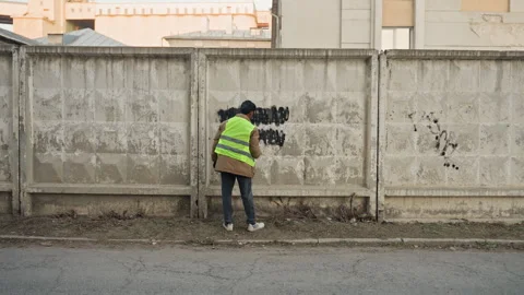 Urban technician fixing wall at dusk. Construction professional in safety gear Stock Footage 332503501