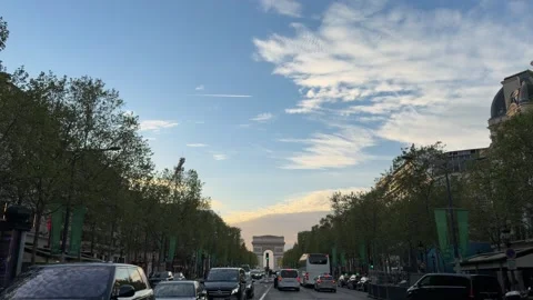 Urban traffic on the Champs-Élysées with the Arc de Triomphe in Paris Stock Footage 337783458