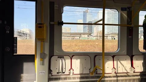 Urban train interior with empty seats and cityscape view of skyscrapers thr.. Stock Photos