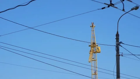 Urban view of lamp posts and electric wires against the sky and construction cra Stock Footage 147534409