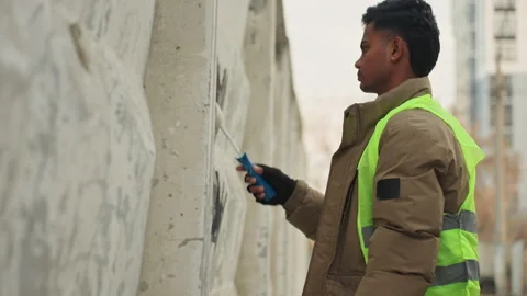 Urban worker carefully patching cracked wall surface. Focused construction Stock Footage 332502727
