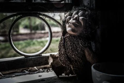 Urbex Italy, creepy macabre puppet, abandoned on a window sill Stock Photos
